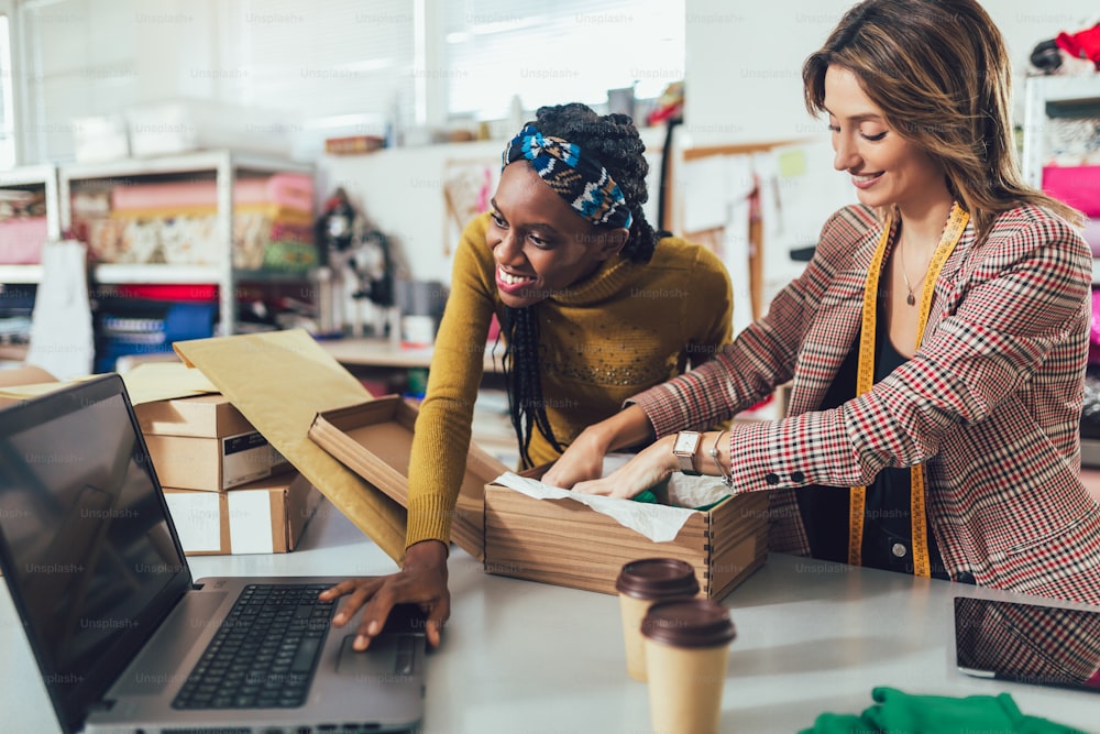 Sales Online. Working women at their store. They accepting new orders online and packing merchandise for customer.