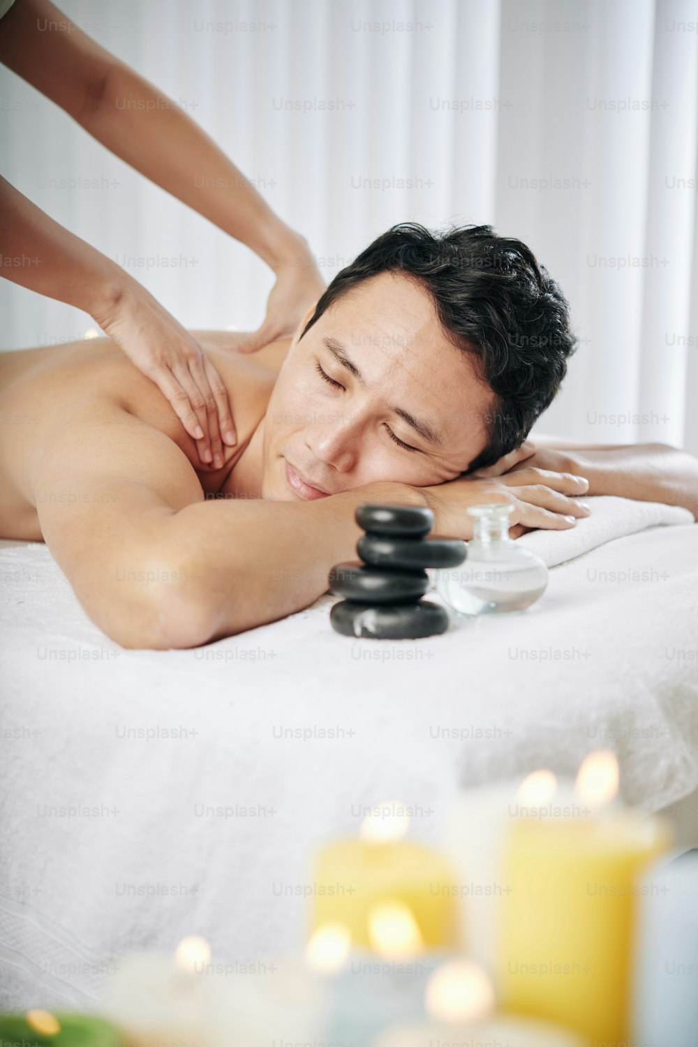 Man enjoying relaxing back massage in spa salon after difficult day at work