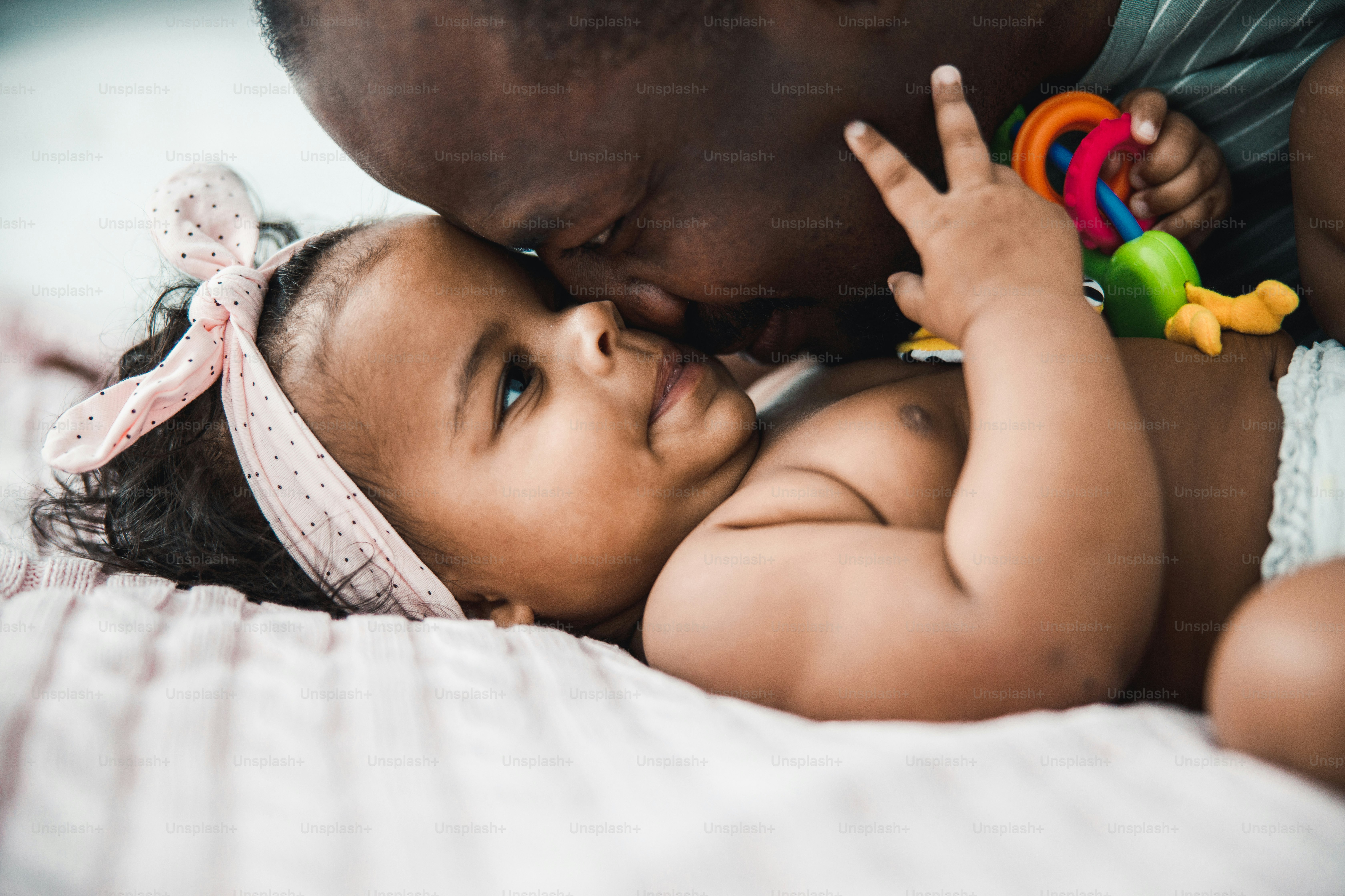 Close up of smiling dad pressing nose to face of adorable child stock photo