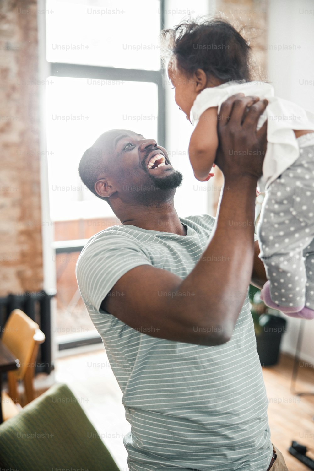 Glücklicher Vater hält neugeborene Tochter und Lächeln Stockfotografie