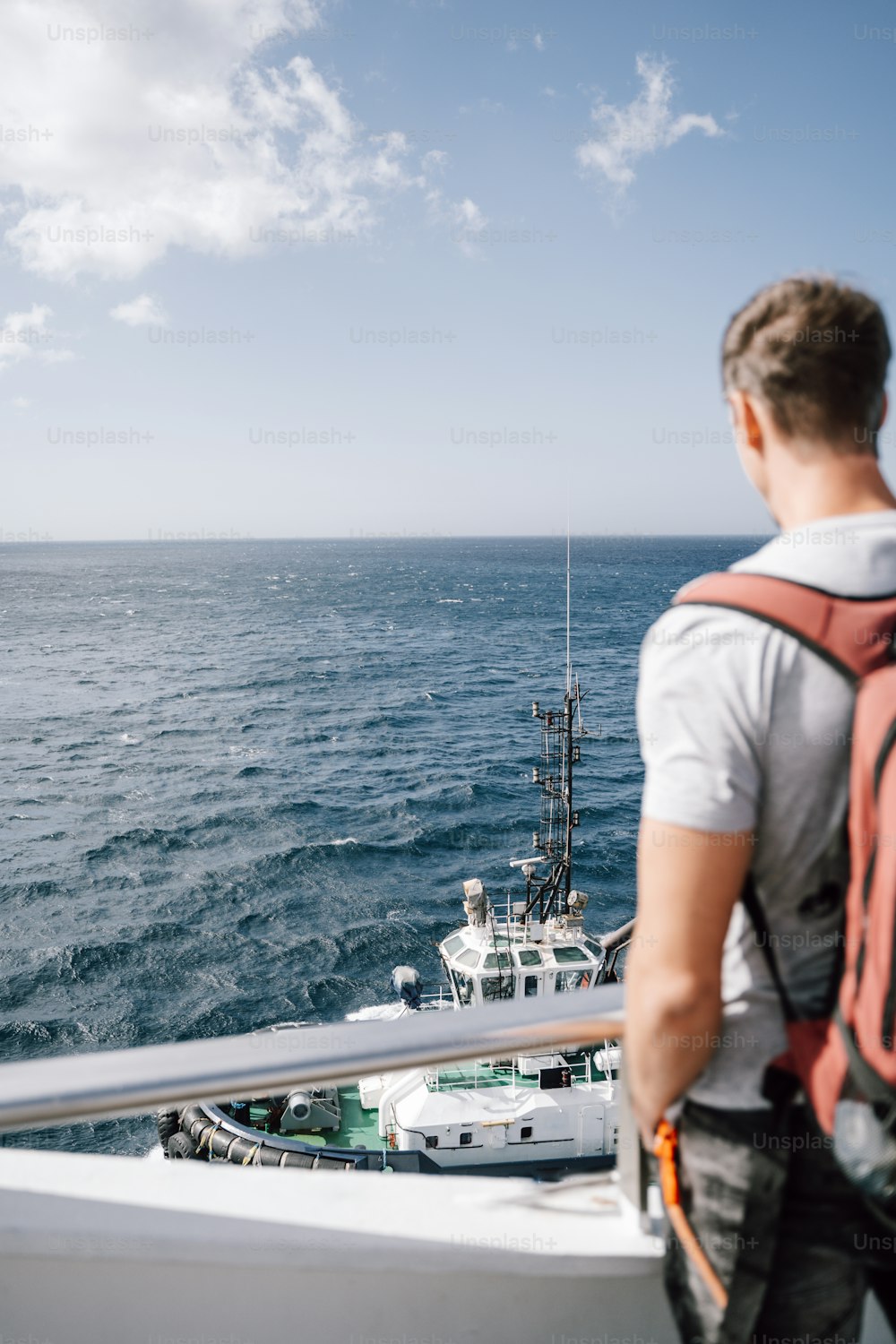 um homem em pé em um barco olhando para o oceano