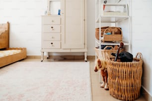 a room with a bed, a dresser, and a basket on the floor