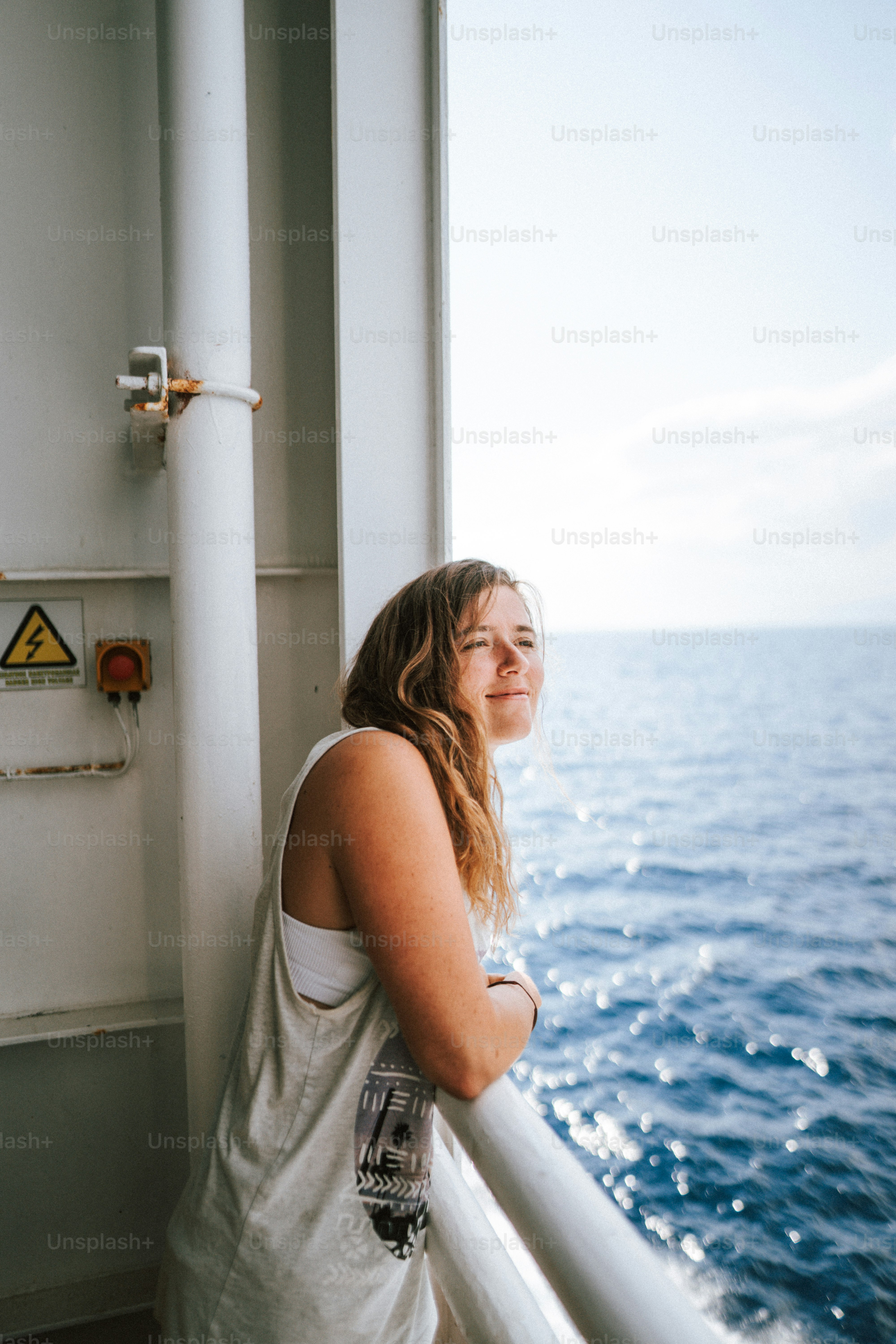 A woman standing on a boat looking out at the ocean photo – Holiday ...