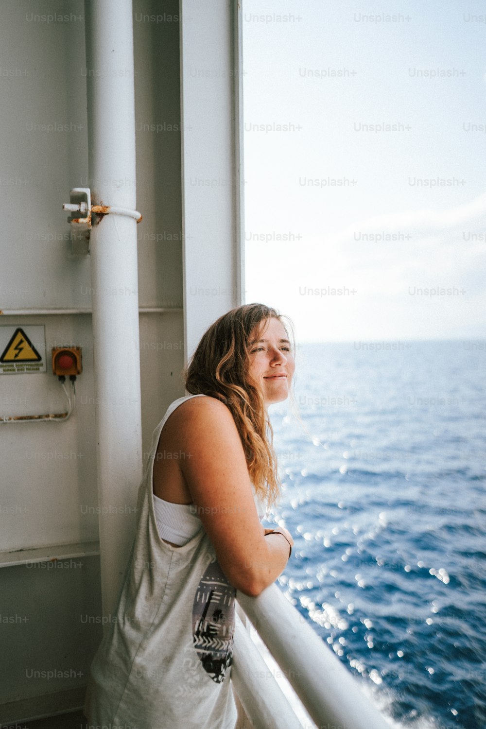 uma mulher em pé em um barco olhando para o oceano