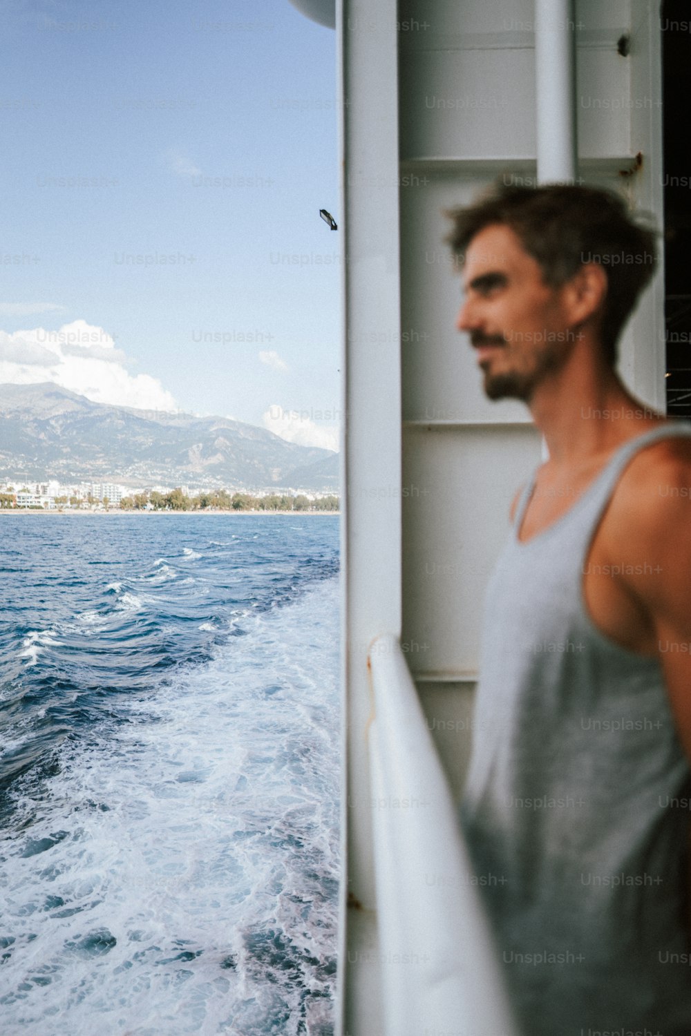 Ein Mann, der auf einem Boot steht und auf das Wasser schaut