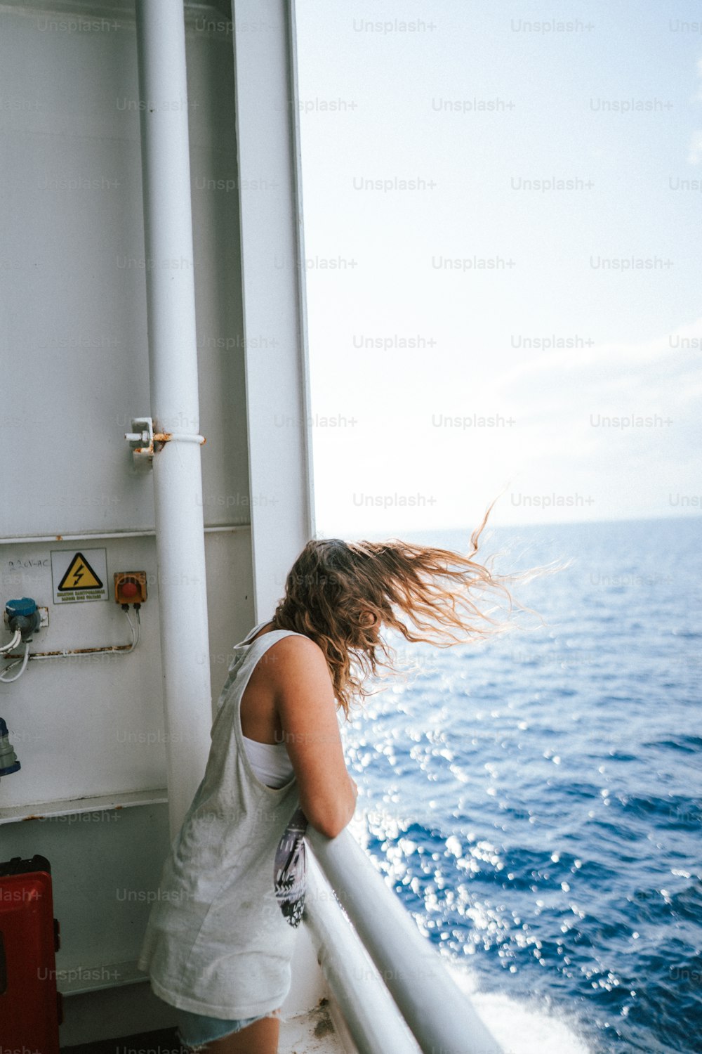 Eine Frau, die auf einem Boot steht und auf den Ozean blickt