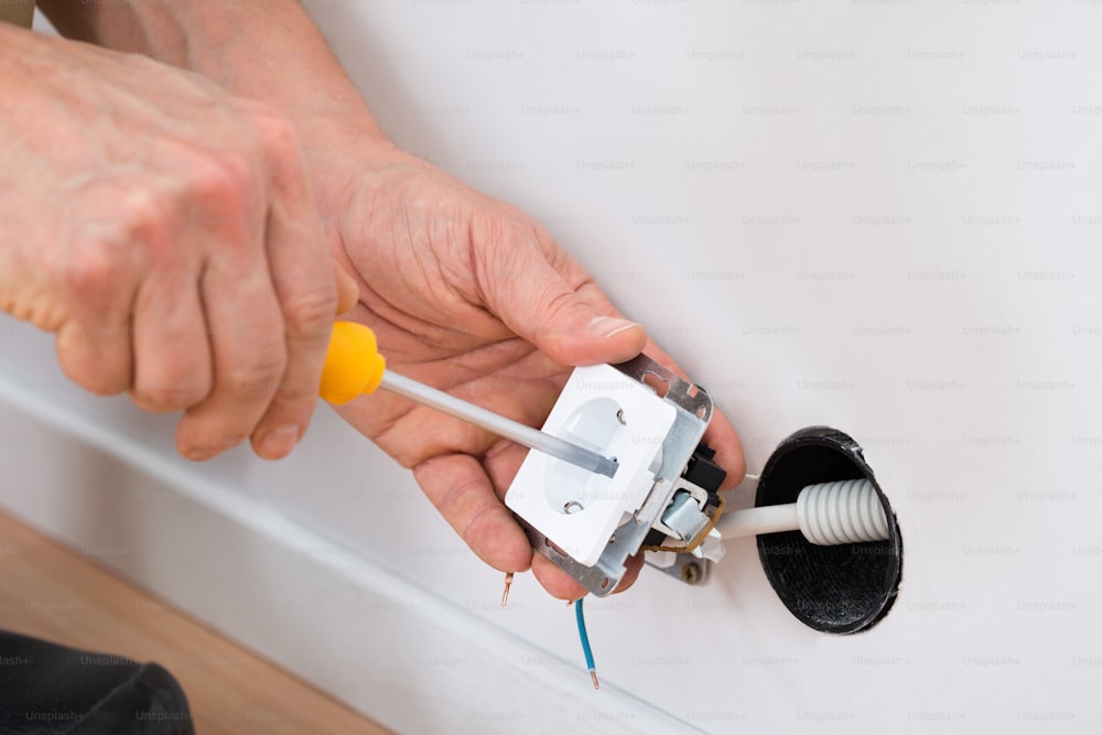 Close-up Of A Technician Fixing Socket With Screwdriver