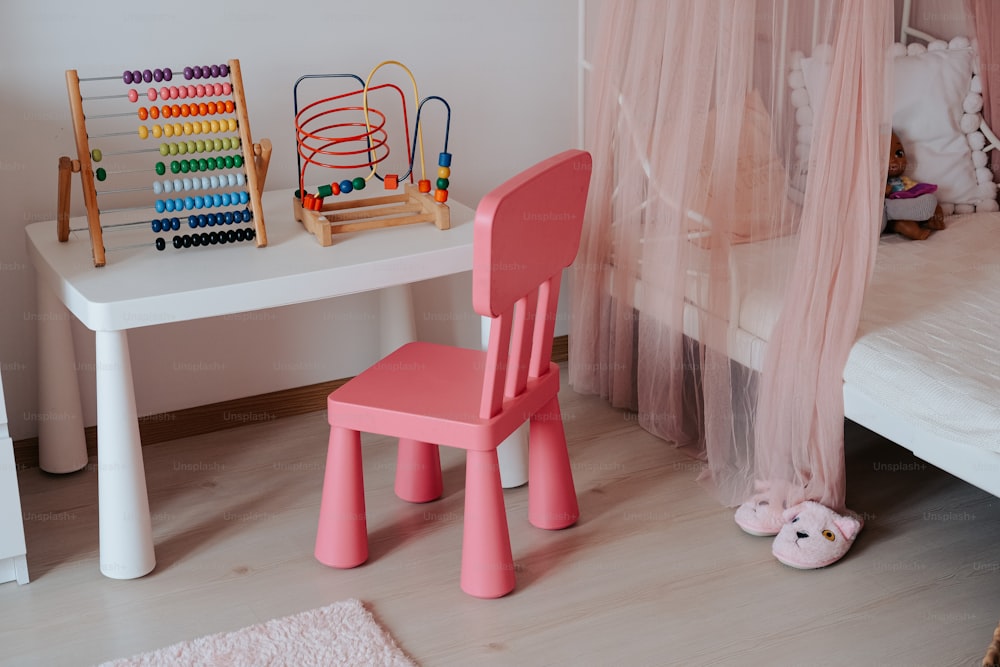 a child's bedroom with pink furniture and accessories