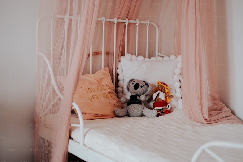 un letto bianco con un baldacchino rosa sopra di esso
