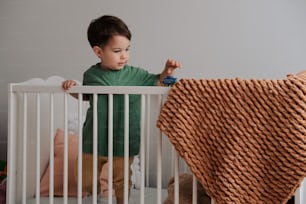 a little boy that is standing in a crib