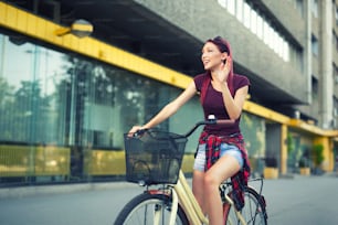 도시 배경에 자전거를 탄 어린 소녀의 초상화