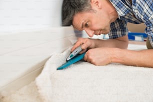 Close-up Of A Craftsman Cutting Carpet With Cutter