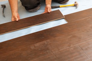 Man Installing New Laminate Wood Flooring Abstract.