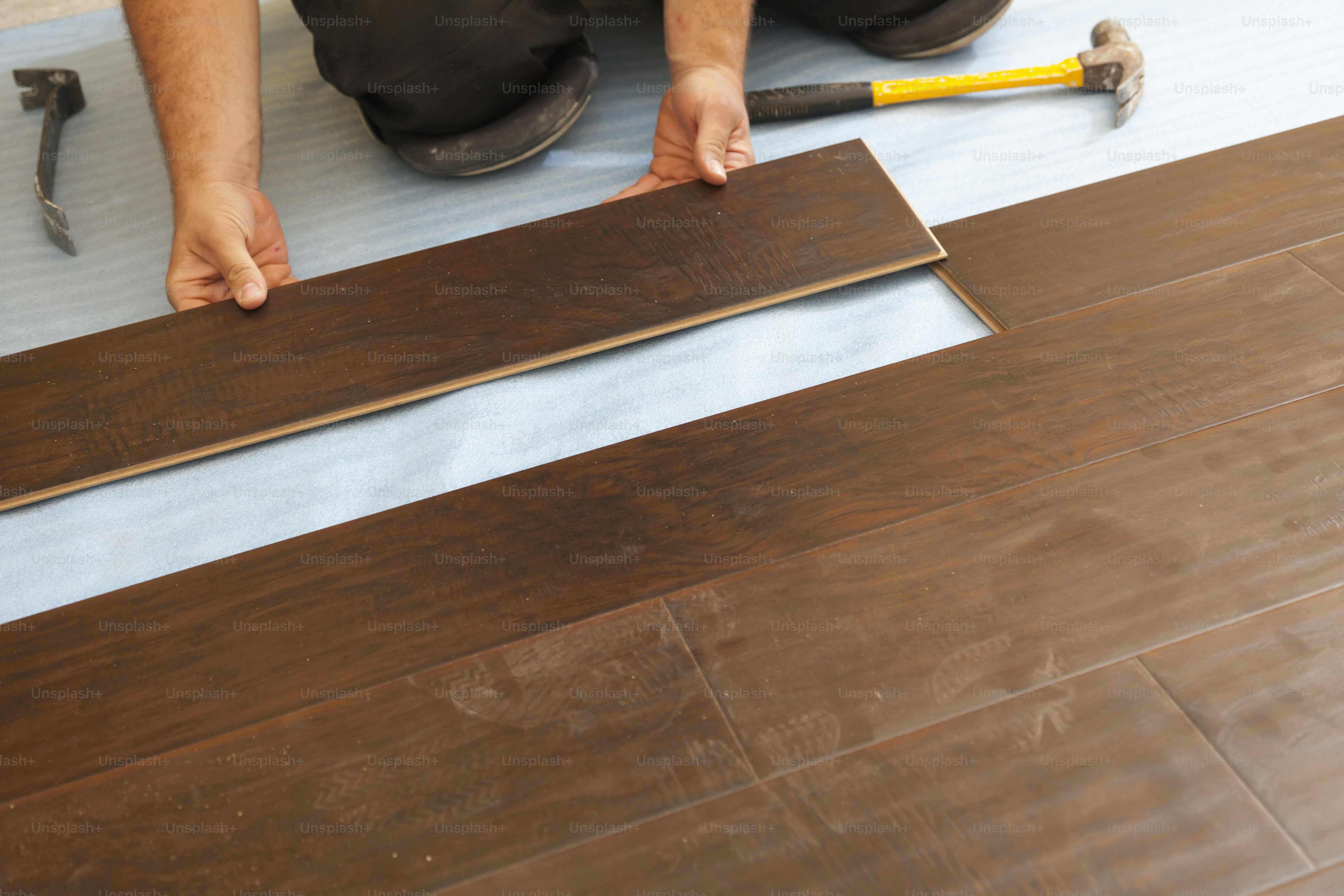 Man Installing New Laminate Wood Flooring Abstract.
