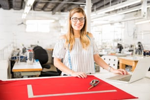Beautiful young woman doing some design work in a textile factory