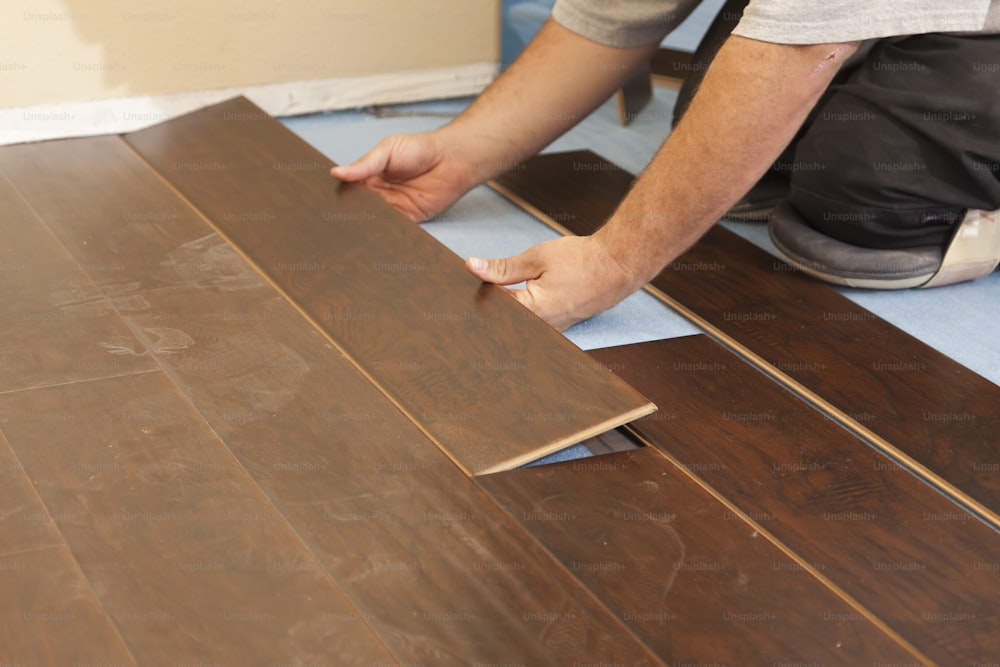 Man Installing New Laminate Wood Flooring Abstract.