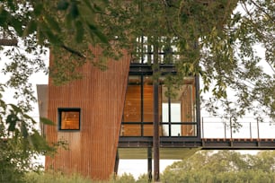 un edificio alto de madera con una ventana de vidrio en la parte superior