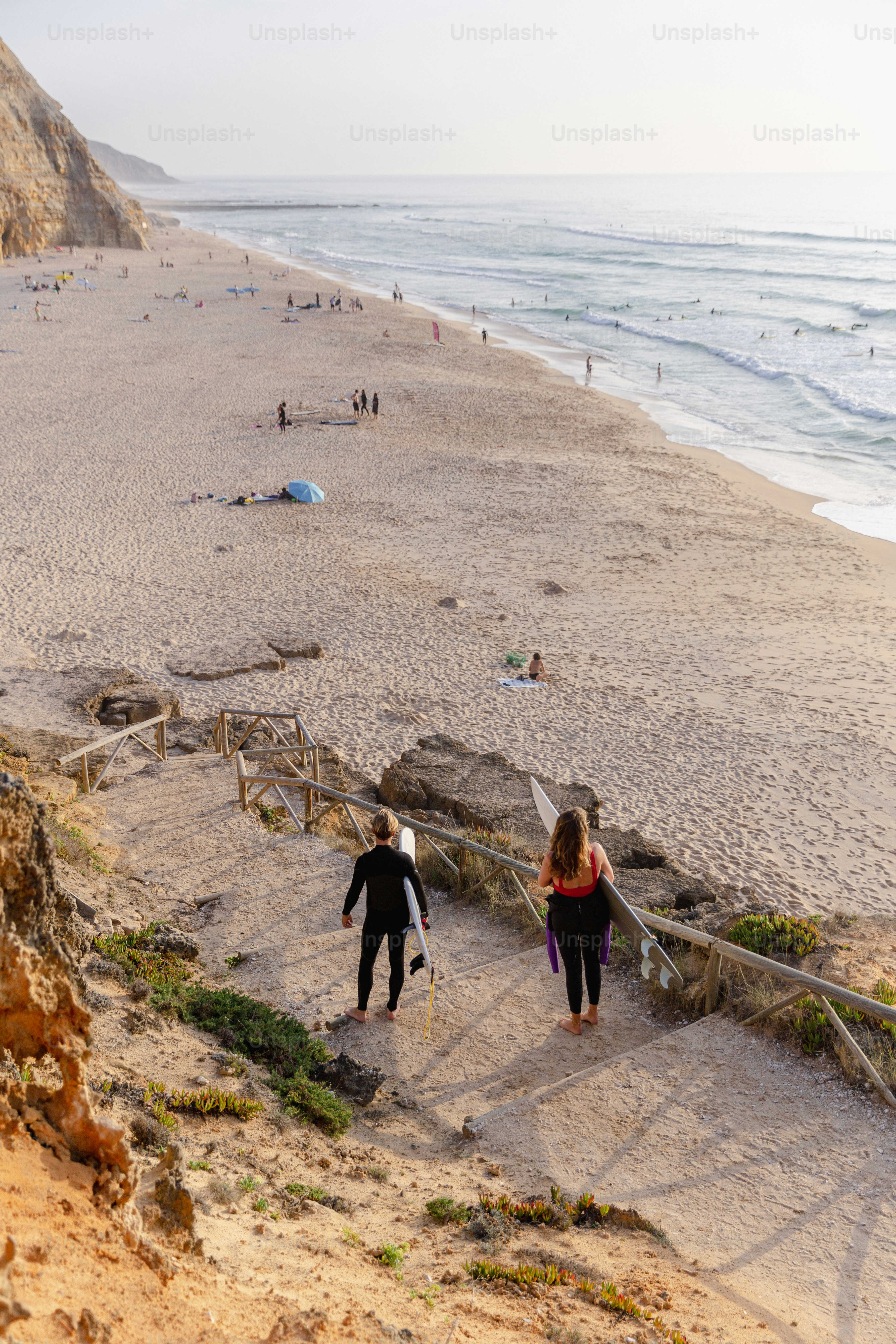 Ein paar Leute, die eine Treppe am Strand hinaufgehen