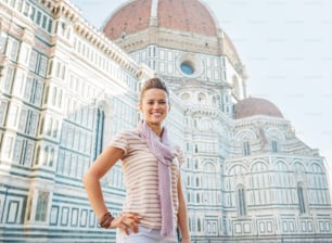Portrait of happy young woman standing in front of cattedrale di santa maria del fiore in florence, italy