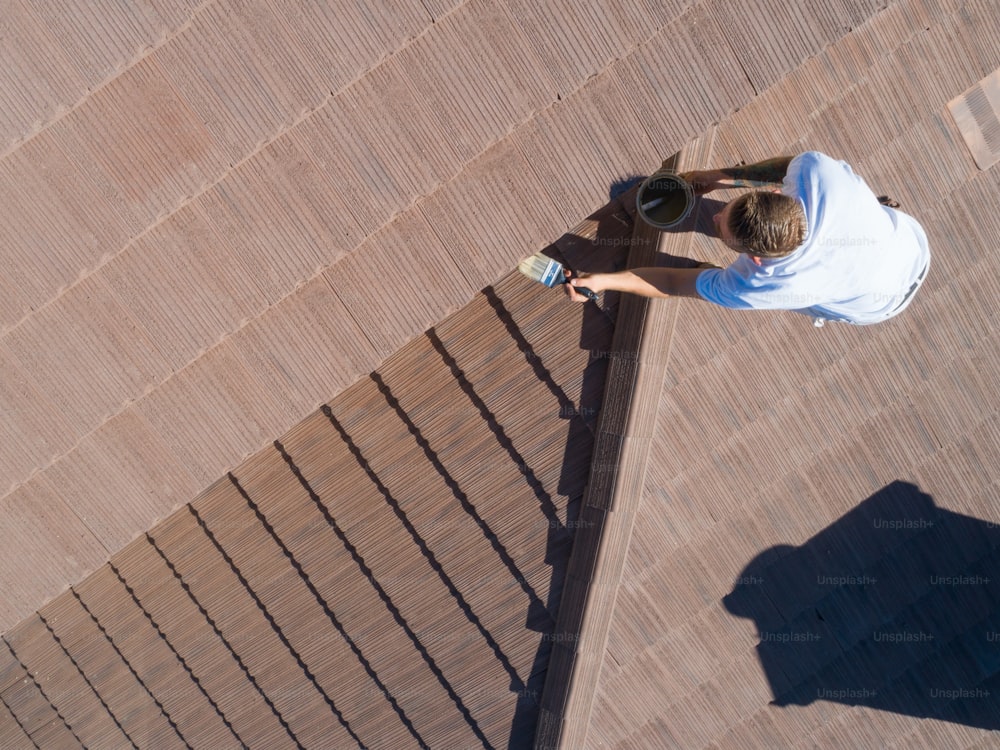 Professional Painter Using A Brush to Paint House Fascia.