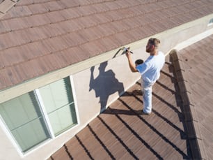 Professional Painter Using A Brush to Paint House Fascia.