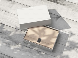 야외에서 나무 테이블에 크래프트 포장지가 있는 흰색 판지 선물 상자 모형을 열었습니다. 3D 렌더링