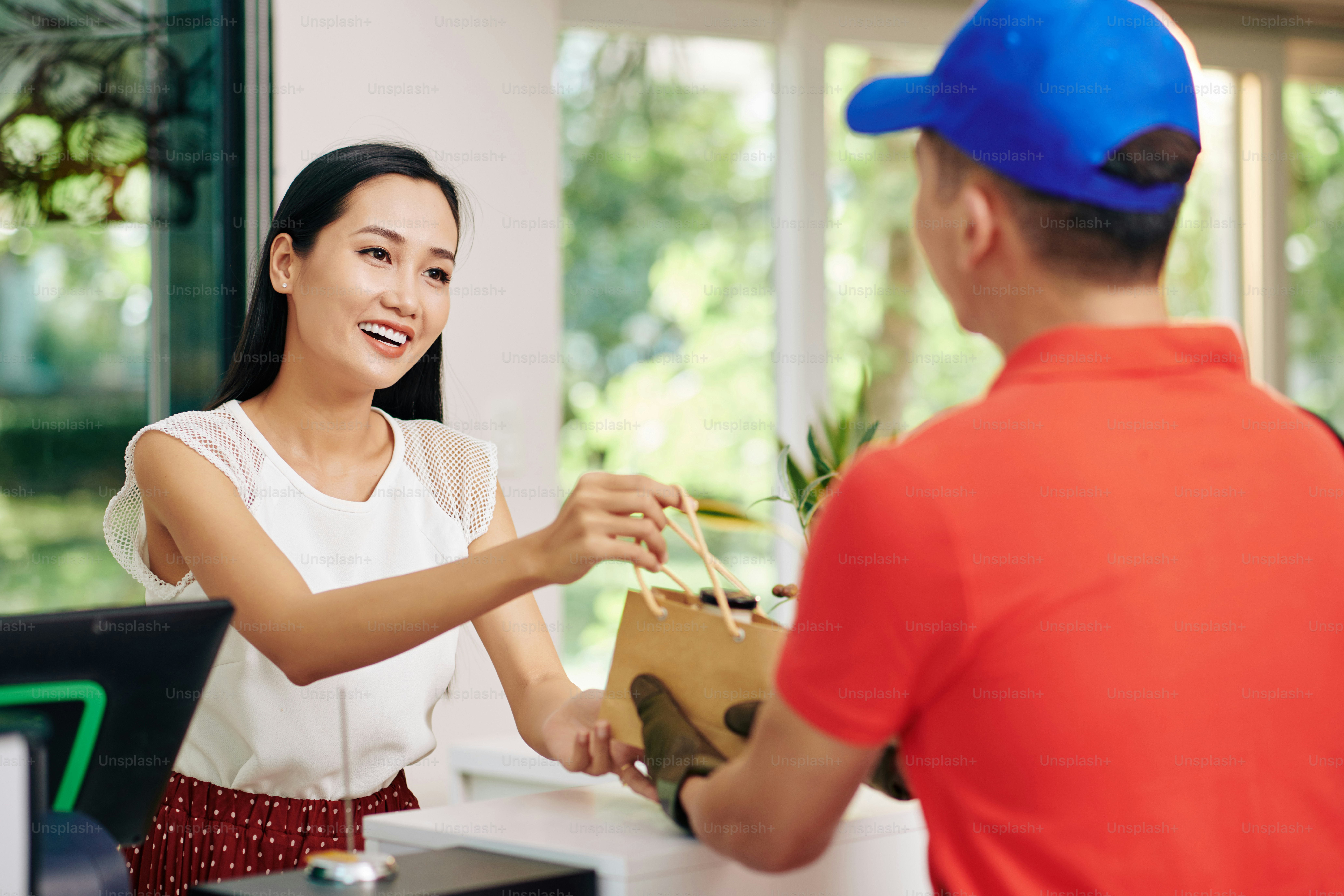 Courier delivering fresh dairy products to coffeeshop and giving ...