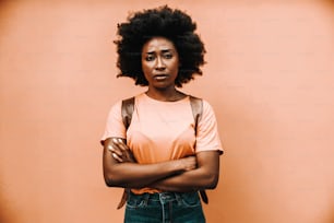 Young attractive african woman standing outdoors with arms crossed and having serious facial expression.