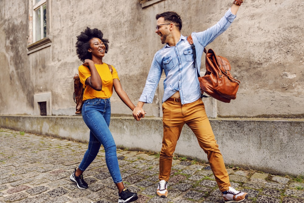 Young cute multicultural couple taking a walk in an old part of the town.