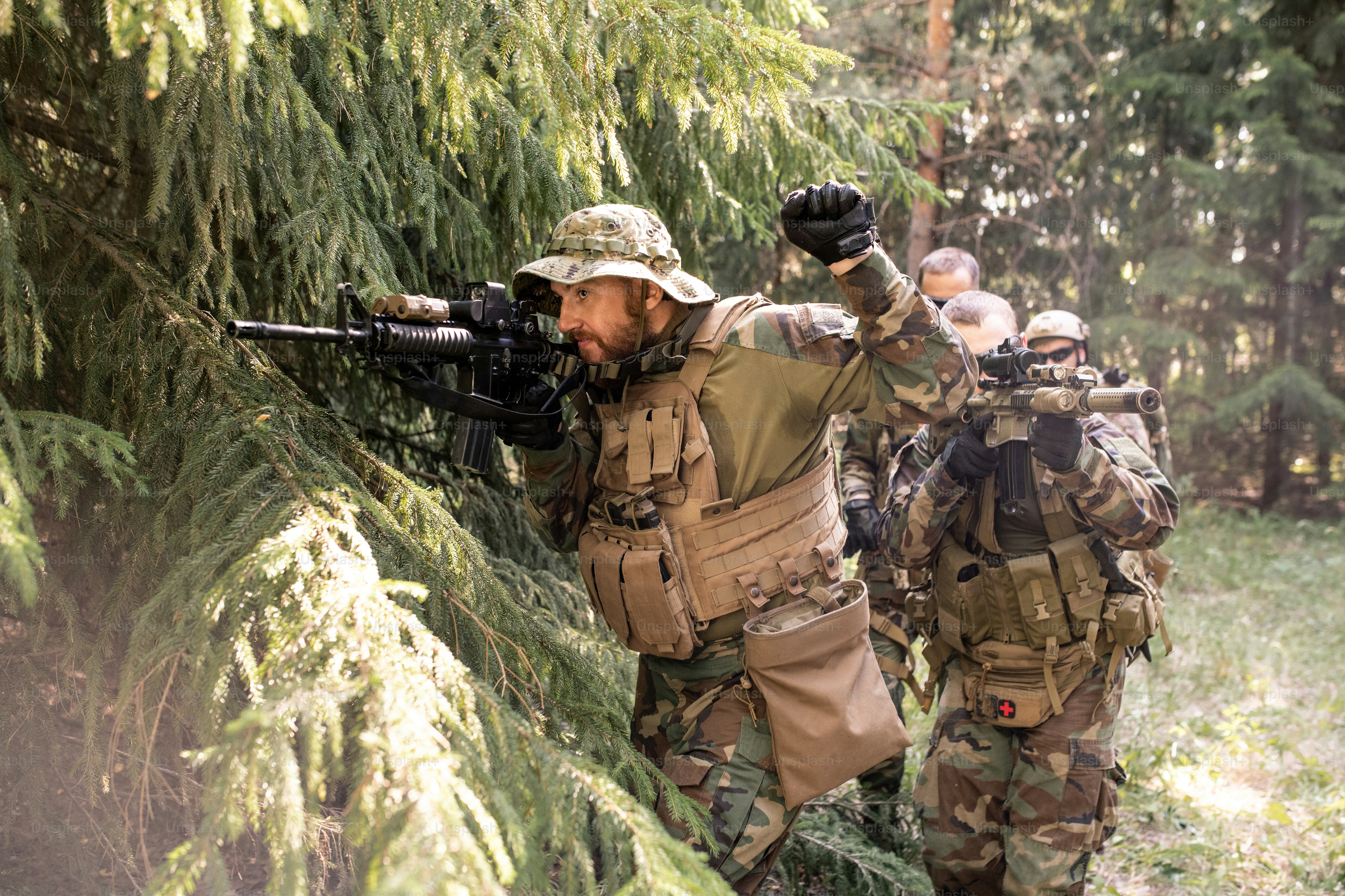 Military leader looking though rifle scope and preparing his team for attack