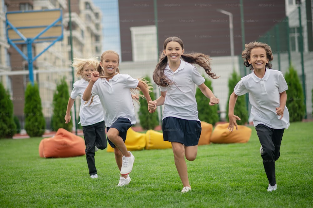 Active mood. Group of children running and looking happy