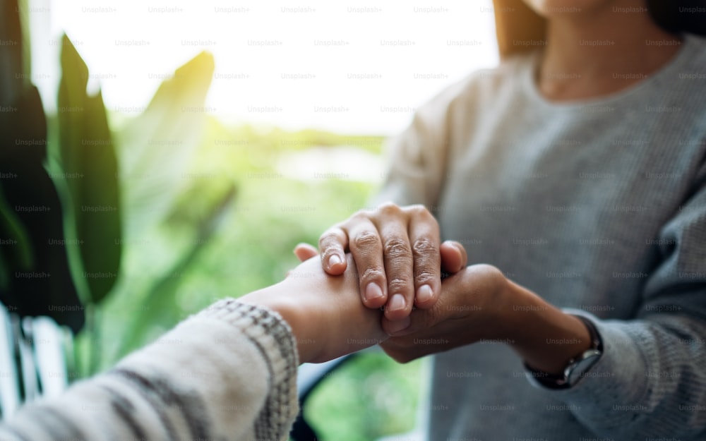 Women holding each other hands for comfort and sympathy