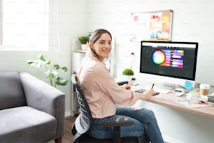 Attractive woman working as a graphic designer with a graphic tablet and choosing the right colors