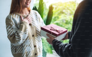A boyfriend surprising and giving his girlfriend a gift box