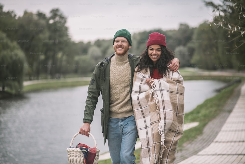 Romantic mood. A happy couple having an autumn date near the pond