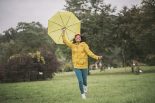 遊び。黄色い傘をさして楽しんでいるかわいいムラッタ