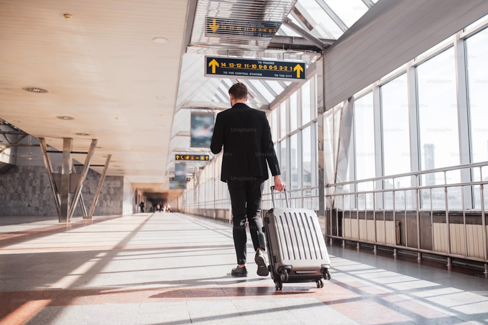 Transition flight. A man carrying his luggage through the airport