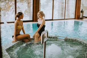 Pretty young women sitting and relaxing by the whirlpool bathtub