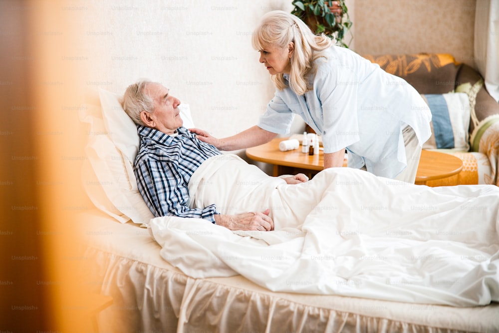 Mature wife taking care of her ill spouse. Elderly love relationship lifestyle and health care conceptÂ