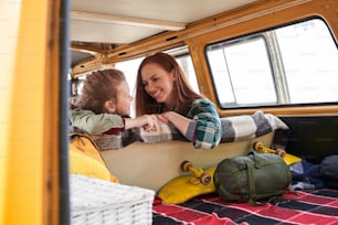 Beaming redhead charming mom and interested kid talking with each other at the car among the woods. Happy parent having leisure with child outdoor concept