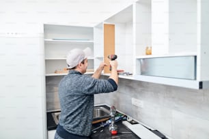 Handyman worker assembling furniture and fixing it.