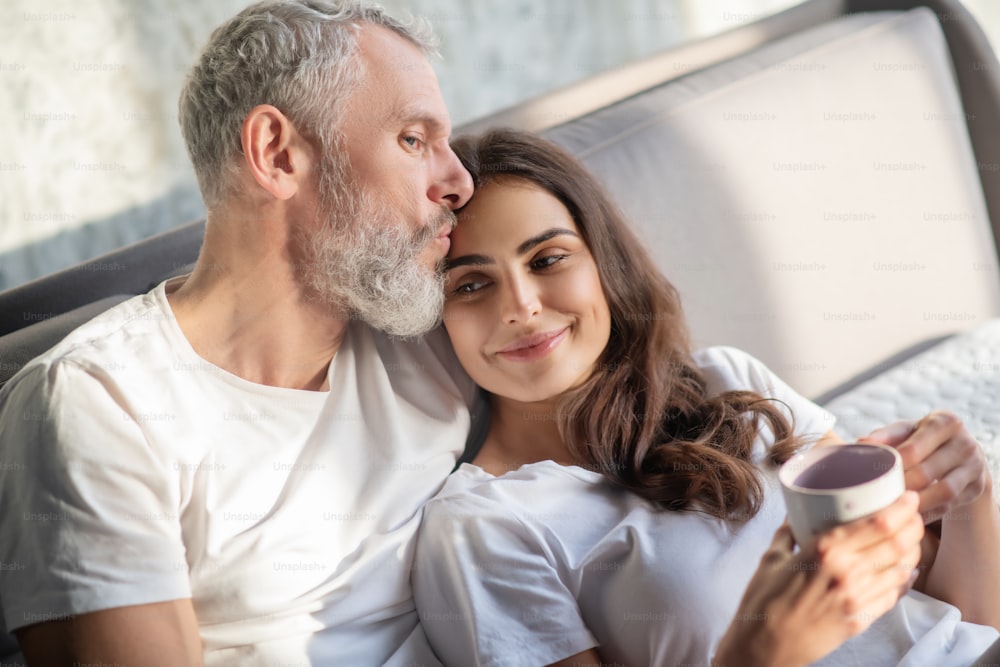 Lazy morning. A couple having morning coffee in the bed