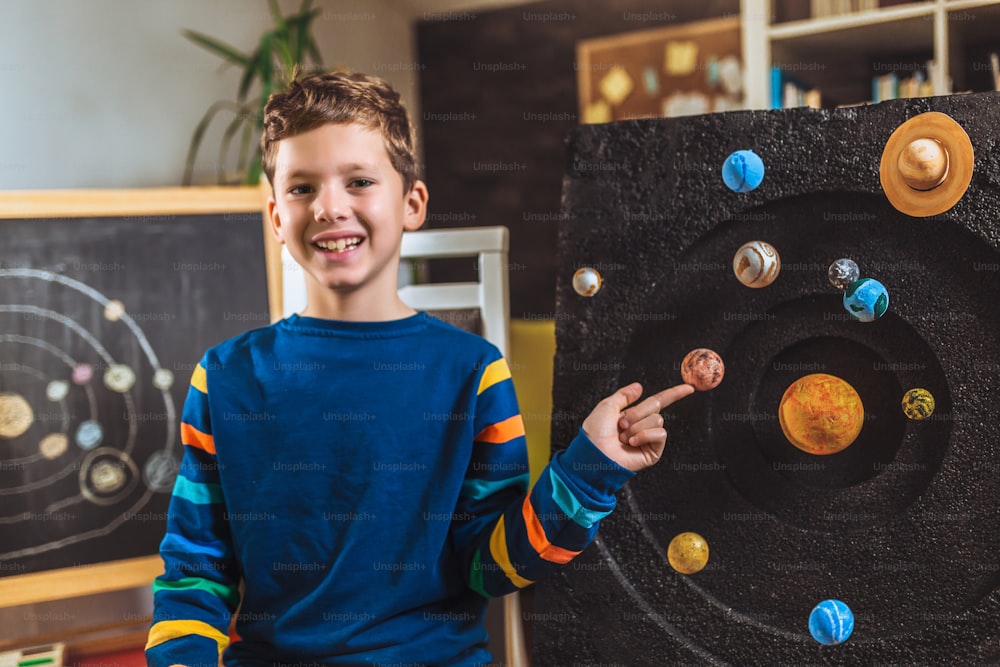 彼の科学の家プロジェクト - 私たちの太陽系の惑星 - を提示する子供。遠隔教育オンライン教育。