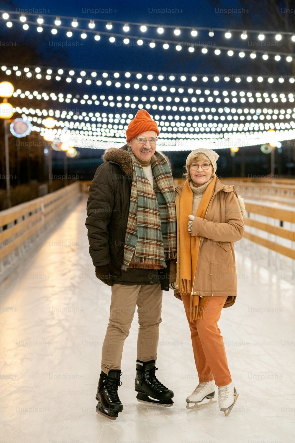Portrait of mature couple smiling at camera during their ride on skates in the park