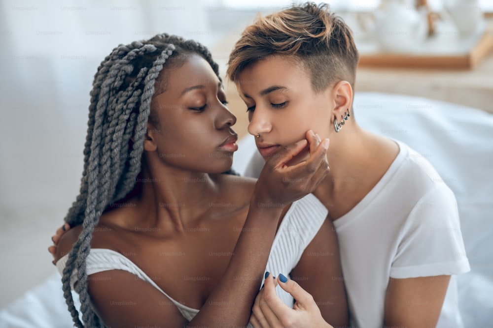 Désir sexuel. Couple de même sexe assis l’un près de l’autre à l’air tendre et passionné