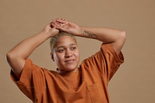 Portrait of carefree short haired woman posing against neutral background in studio, copy space