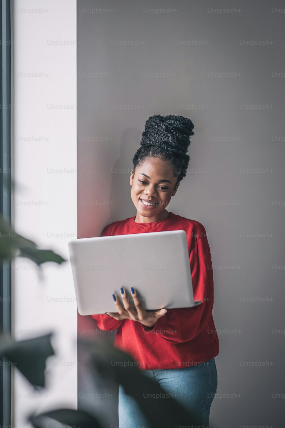 In the office. Black woman in red shirt with a laptop