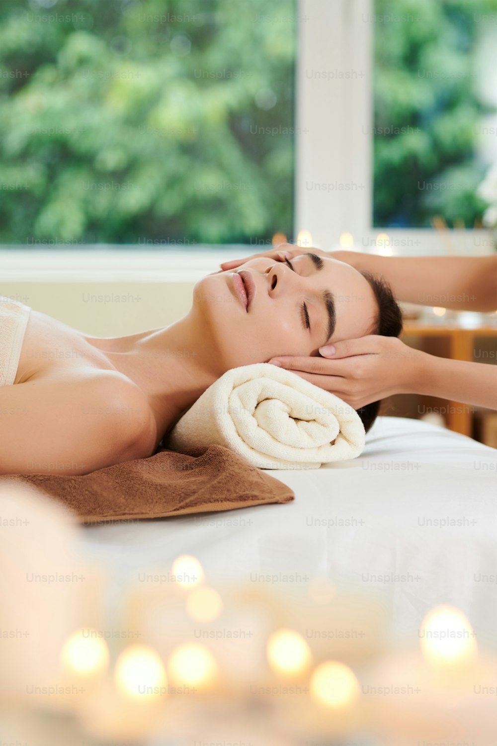 Close-up da mulher que relaxa durante a massagem do spa no salão do spa