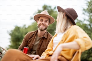 Young cheerful couple having fun, talking together during a picnic outdoors