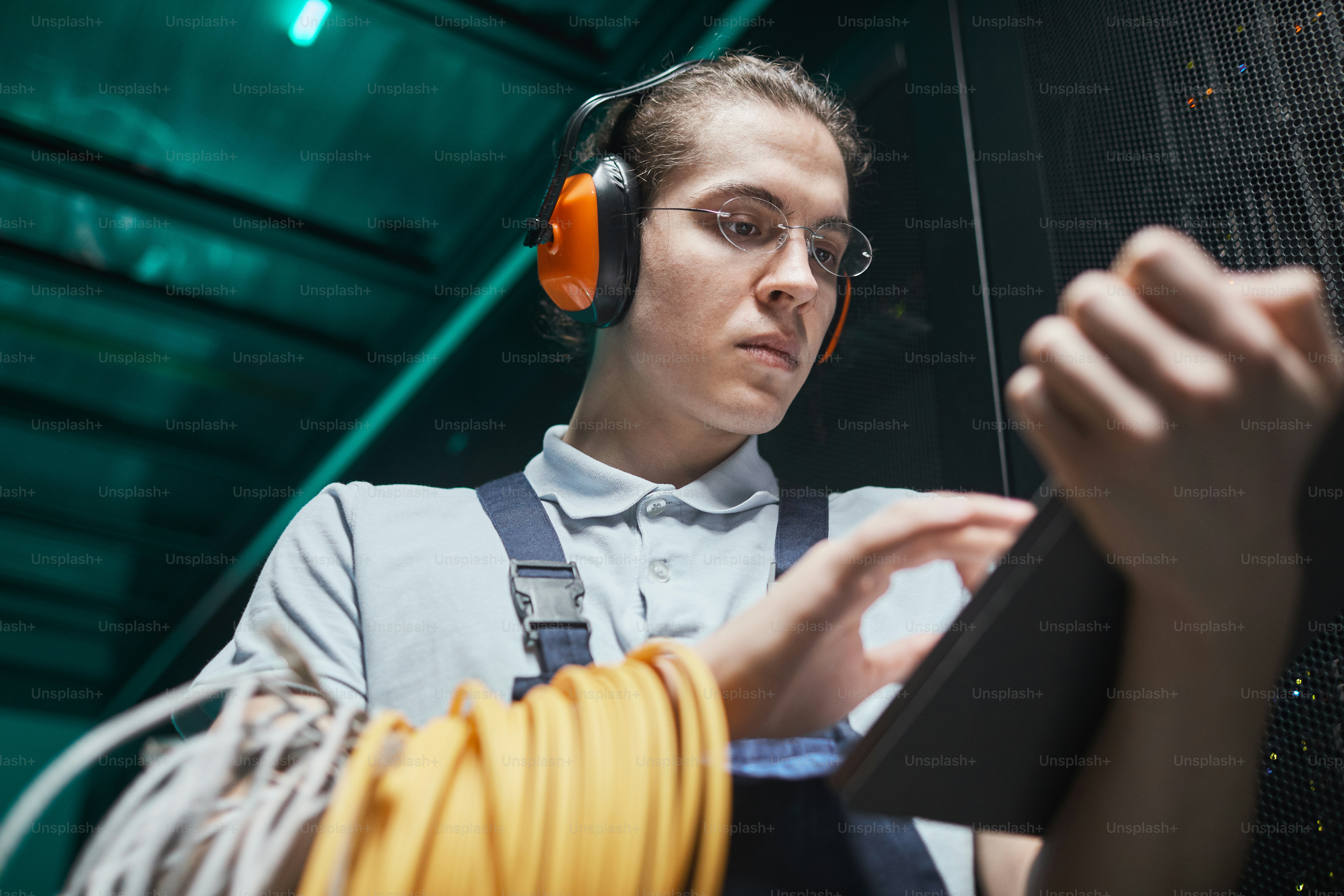 Engineer using a tablet during maintenance in a data center server room